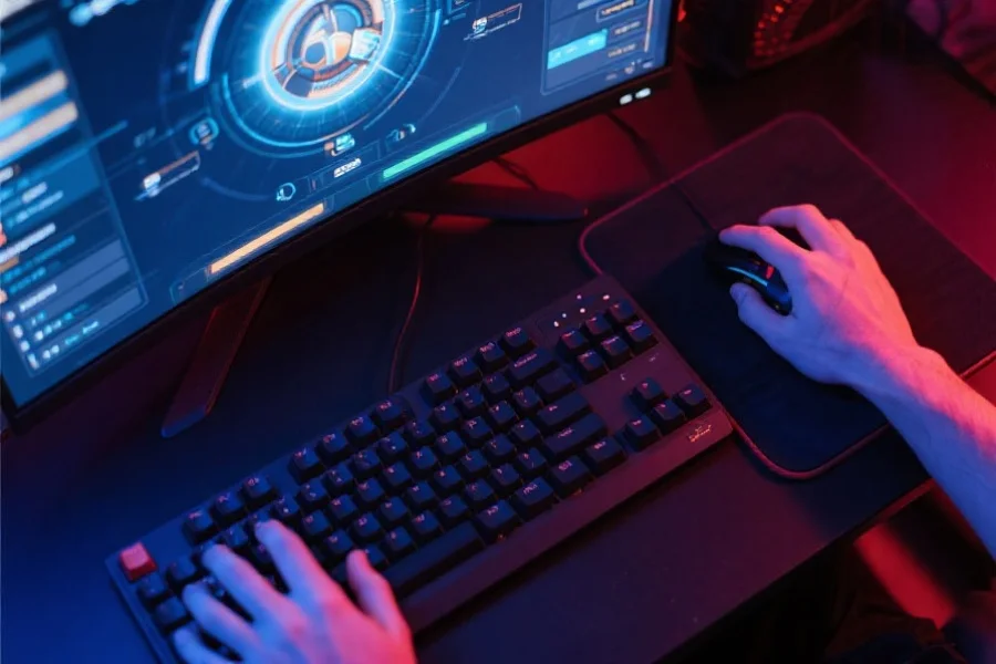 俯视角展示玩家手部在键盘和鼠标上快速操作，屏幕界面清晰，操作流畅